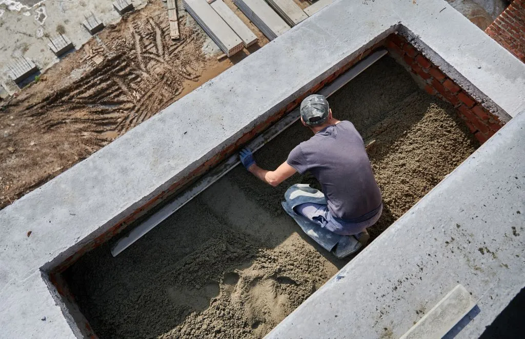 male-worker-screeding-floor-at-construction-site.jpg мужчина
